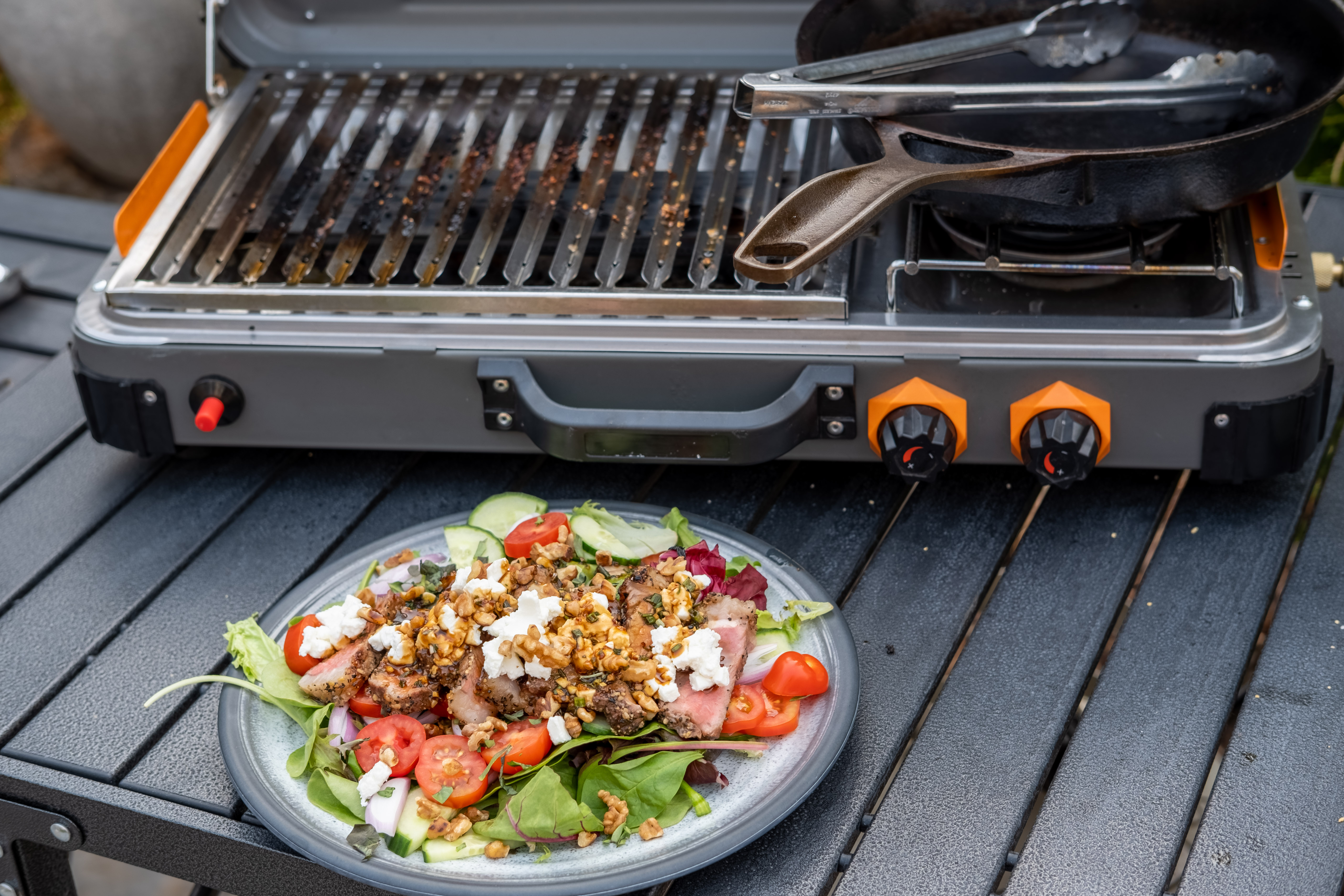 Steak Salad in front of a Kuma Outdoor Gear Grill & Propane Stove that was used to cook the steak and toast the walnuts