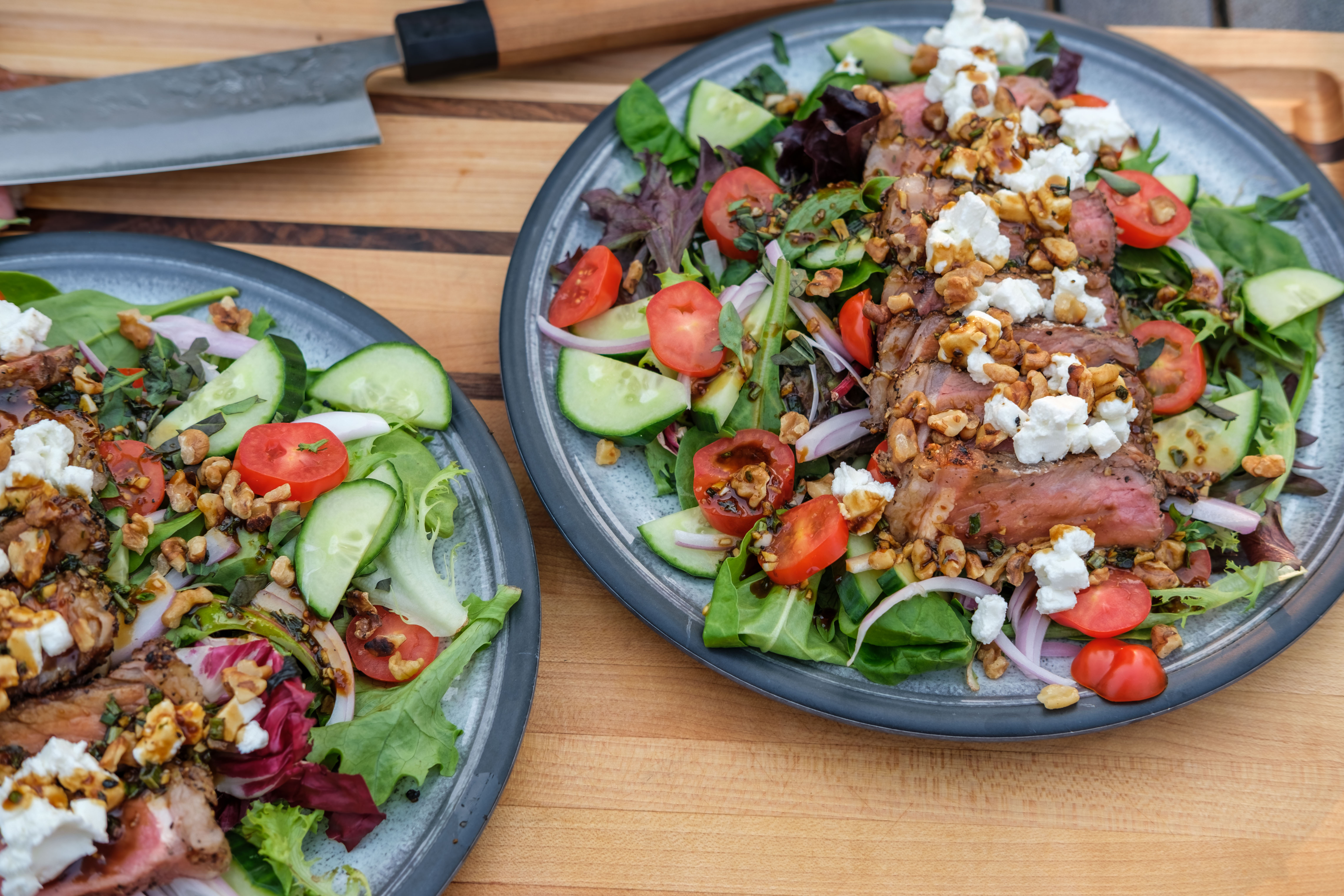 Steak Salad made on a Kuma Outdoor Gear Grill & Propane Stove with toasted walnuts on a plate