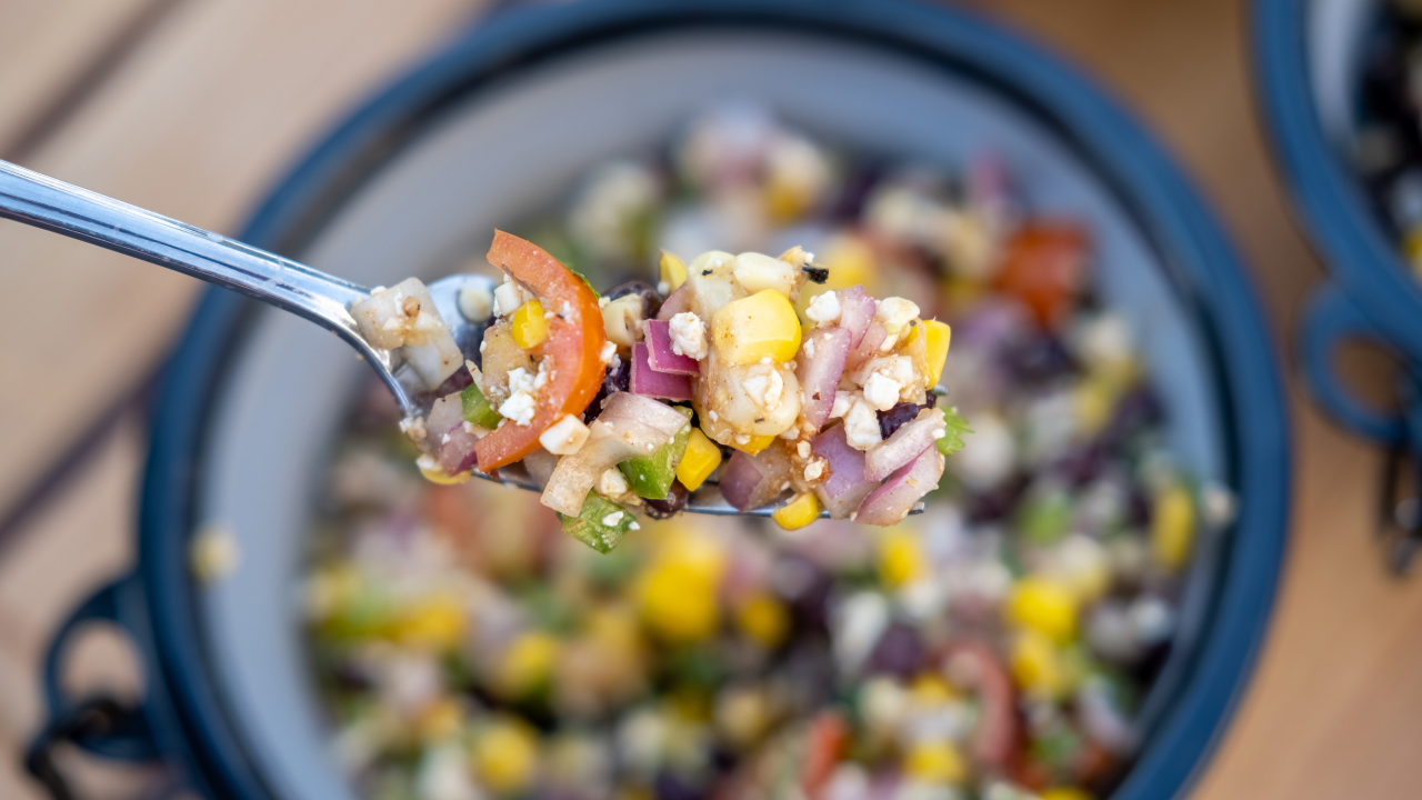Close up of a bite of warm corn salad from the Kuma Kitchen Series