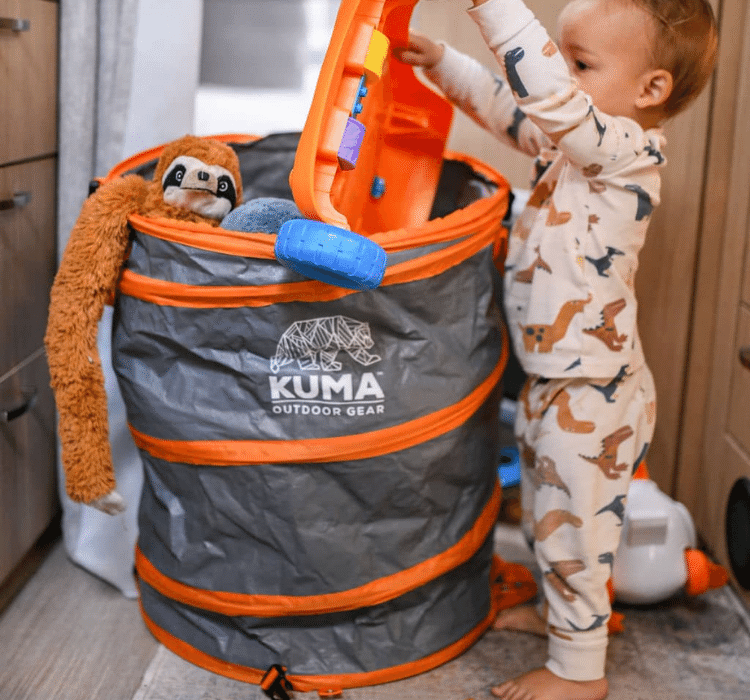 child putting away toys in pop up waste bin